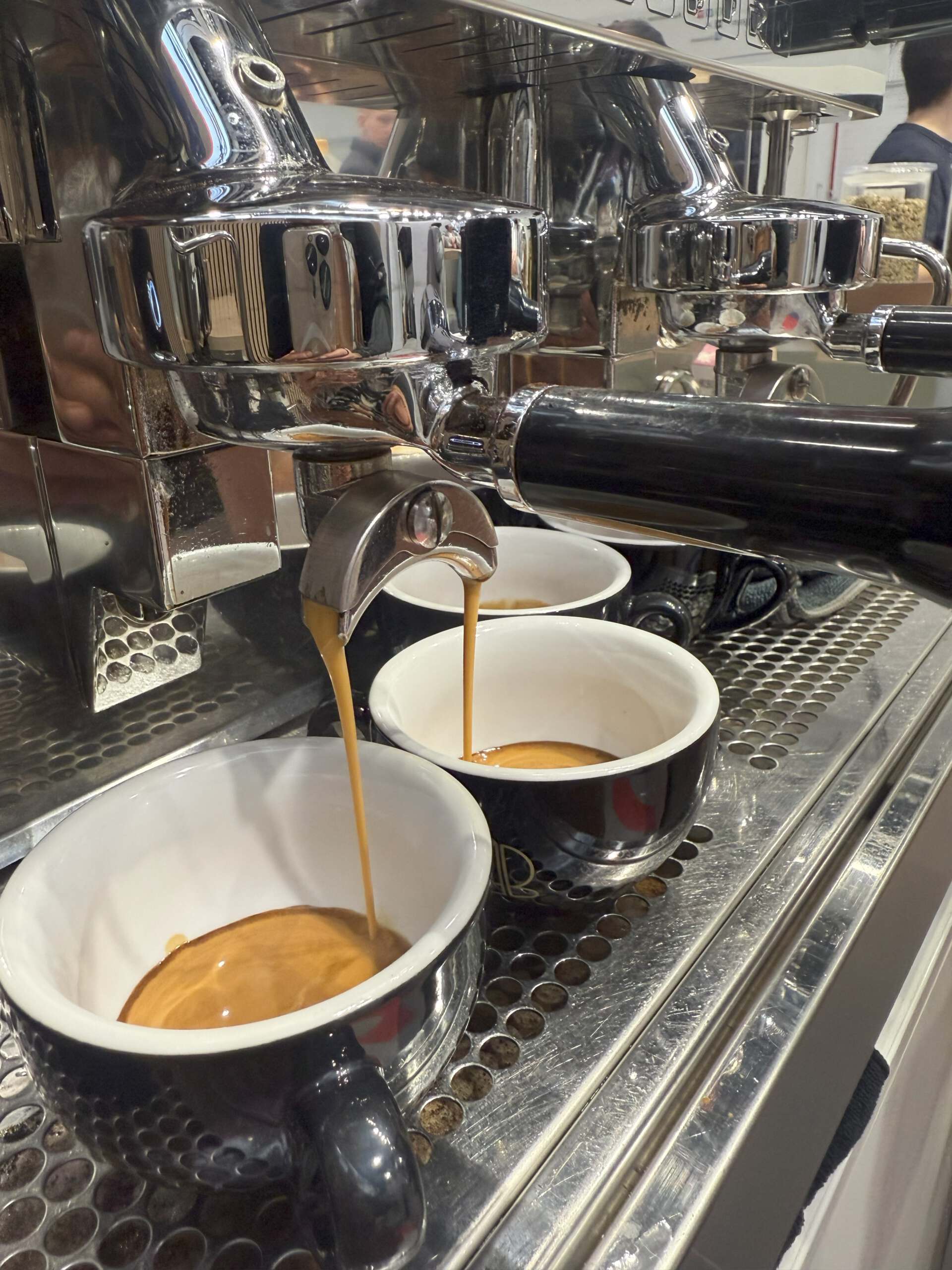 Frisch gebrühter Espresso aus einer professionellen Siebträgermaschine, zubereitet von einem Barista für Kaffeecatering auf Events oder Messen.