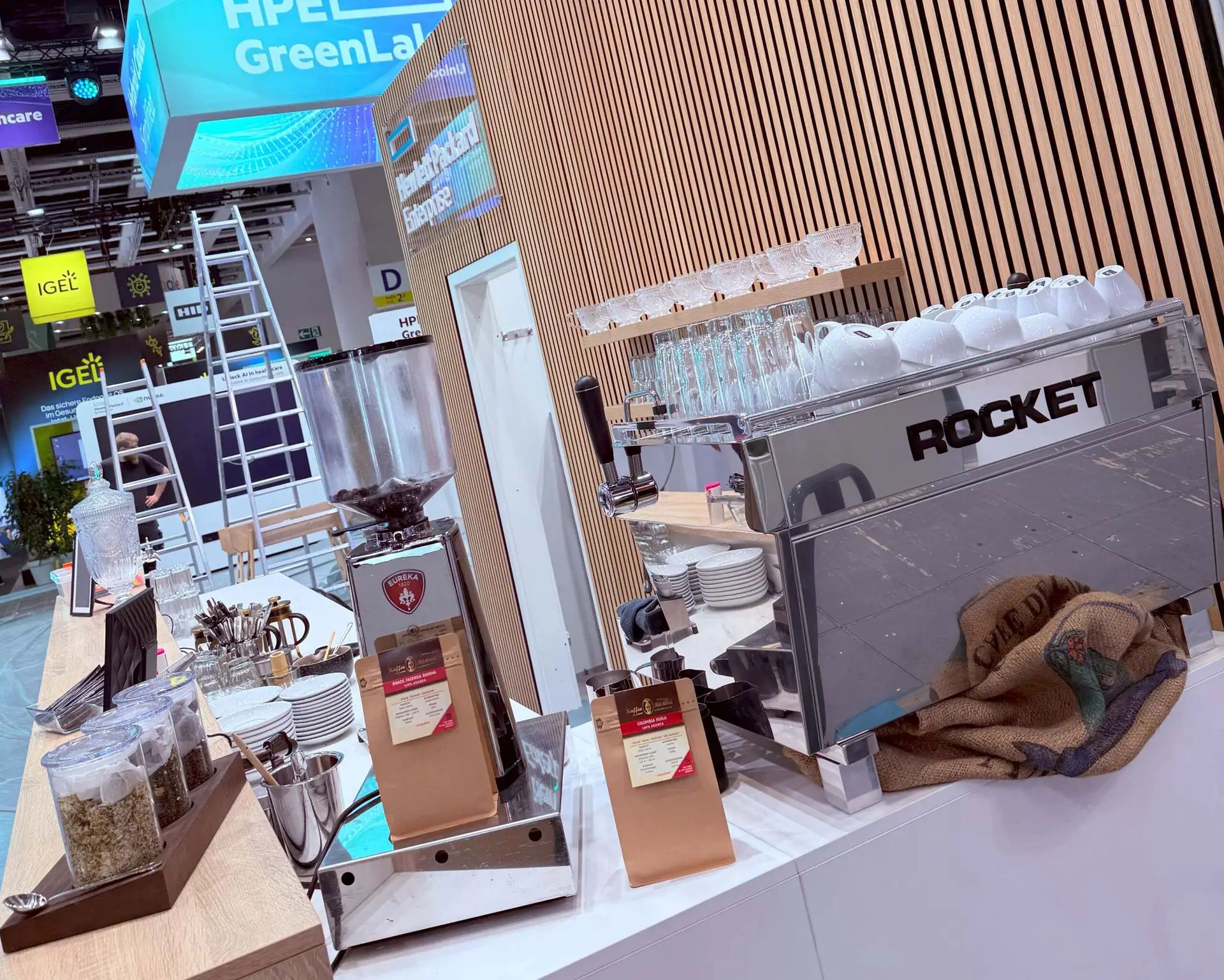 Professioneller Kaffeecatering-Stand auf einer Messe mit Espressomaschine, Kaffeemühle, Kaffeebohnen und Barista-Ausstattung.